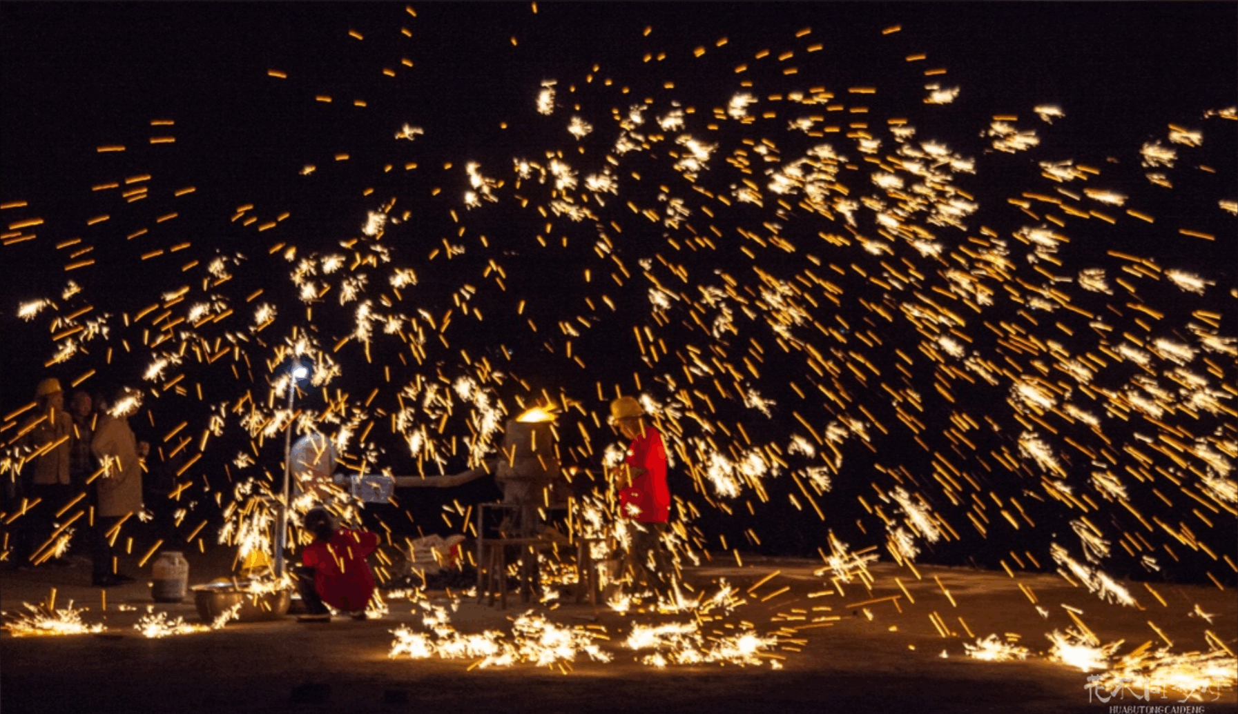 花不同彩灯打铁花表演现场实景,清晰展示了表演核心区、安全隔离带与设置在20米外安全距离的观众观赏区,凸显科学严谨的现场安全管理 花不同彩灯打铁花表演现场实景,清晰展示了表演核心区、安全隔离带与设置在20米外安全距离的观众观赏区,凸显科学严谨的现场安全管理