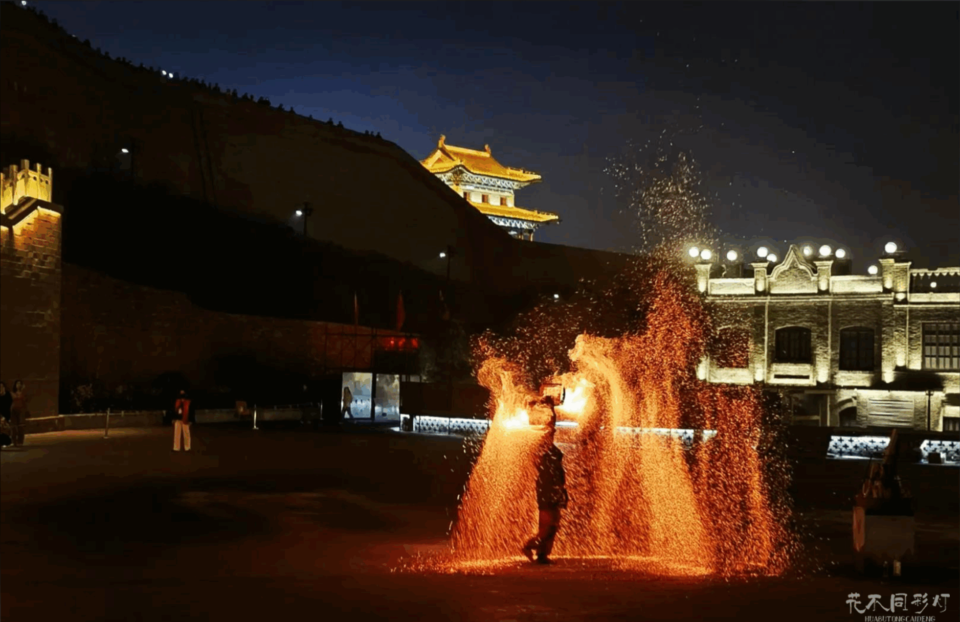 忻州古城打铁花表演者身着古装击打铁水的瞬间，火花如瀑布般倾泻，凸显技艺与古风的结合。