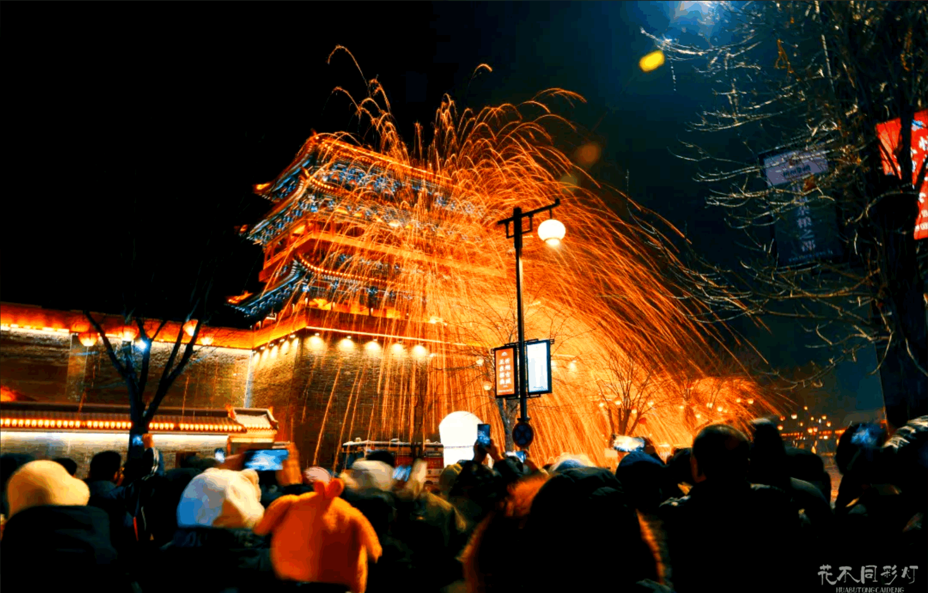 忻州古城打铁花夜间实景，璀璨的铁花在古老的城墙和飞檐上空飞溅，游客在青石街道上驻足观赏，展现非遗与古城的完美融合