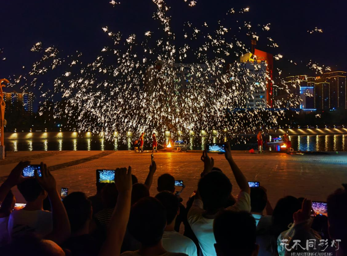 打铁花表演者在孔雀河畔的特制平台上击打铁水,火花如瀑布般倾泻入水,展现水火交融的独特视觉效果。 打铁花表演者在孔雀河畔的特制平台上击打铁水,火花如瀑布般倾泻入水,展现水火交融的独特视觉效果。