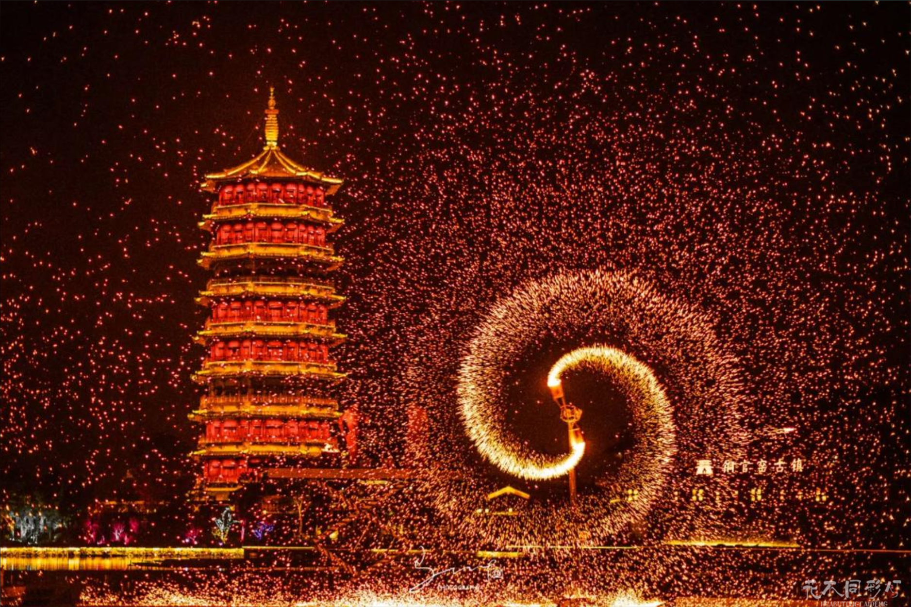 铜官窑古镇夜间打铁花表演盛况，璀璨铁花在仿唐建筑群上空绽放，与古镇窑火文化主题完美融合，游客在石阶上驻足观赏
